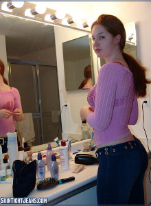 Redhead chick with long hair has her tasty apple ass fit into tight jeans with the tiny pink string panties thong visible