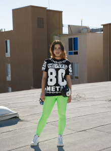 Pretty chick is on the building roof in green spandex