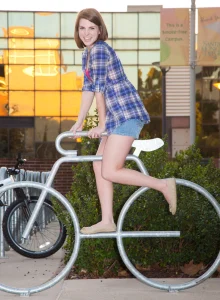 Amazing beauty is outside on the grass in jeans shorts