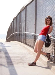 Brunette hottie is going to the beach in tight shorts and playing on the beach in swimsuit with cameltoe