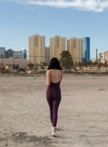 Busty brunette wearing tight violet spandex suit with cameltoe and stretching nipples