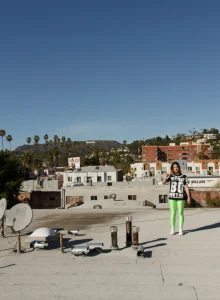 Pretty chick is on the building roof in green spandex