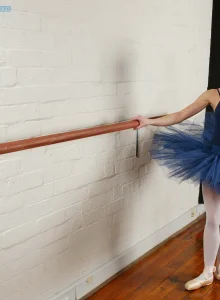 Sexy ballerina in tight outfit with the legs covered with white nylon does exciting flexible poses before strips